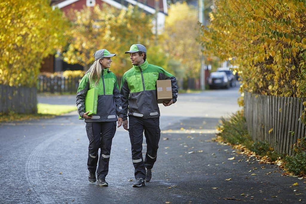 Två Bringanställda som bär paket